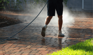 a person spraying a brick walkway, paver cleaning in Lakeland, FL