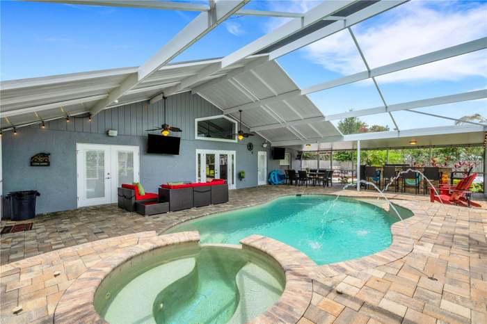 a pool and hot tub in a house with patio