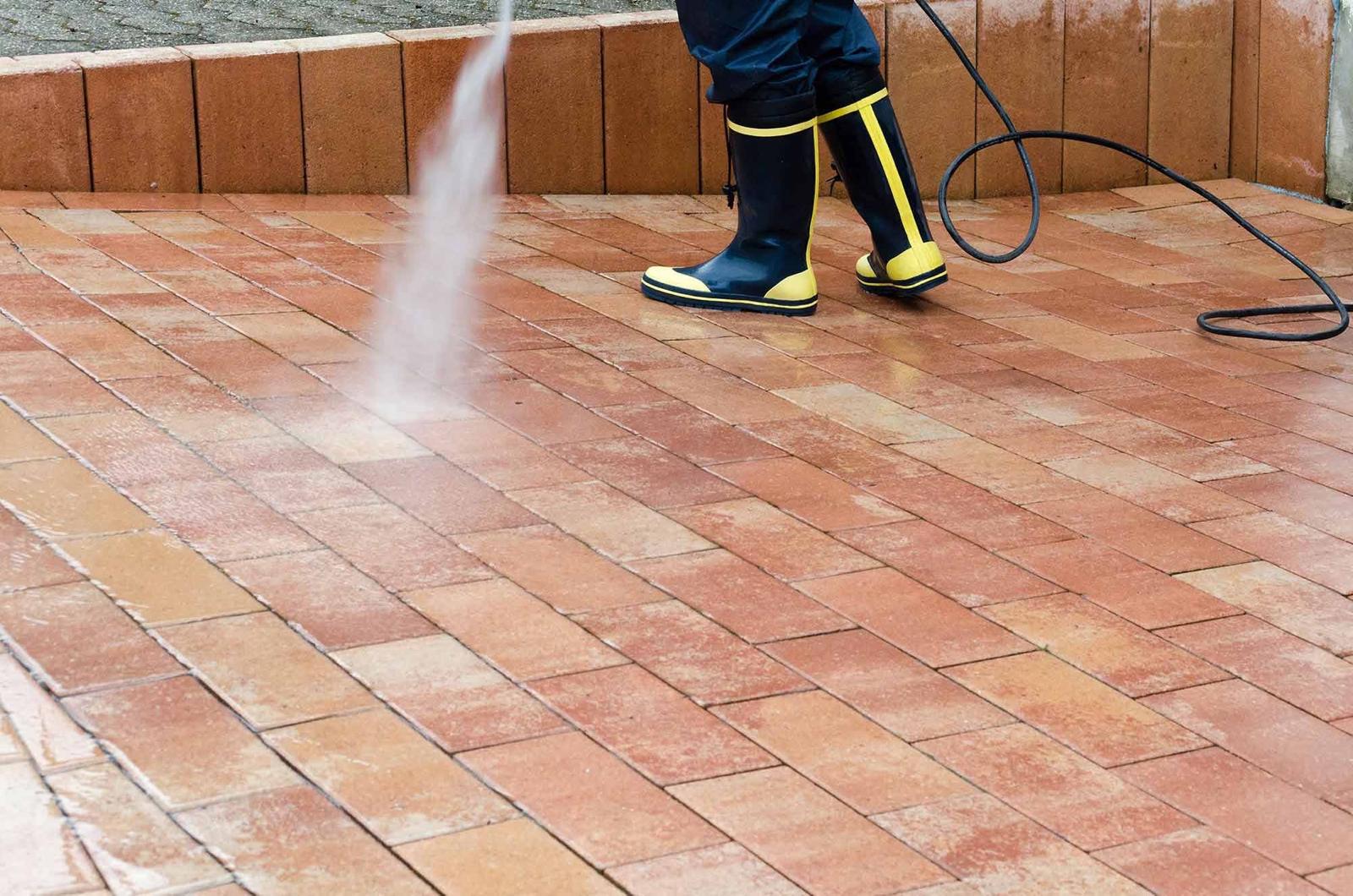 a person spraying a brick surface