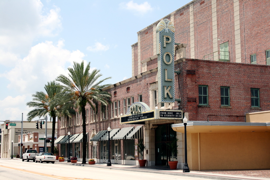 a building with palm trees and a sign in Polk Theatre