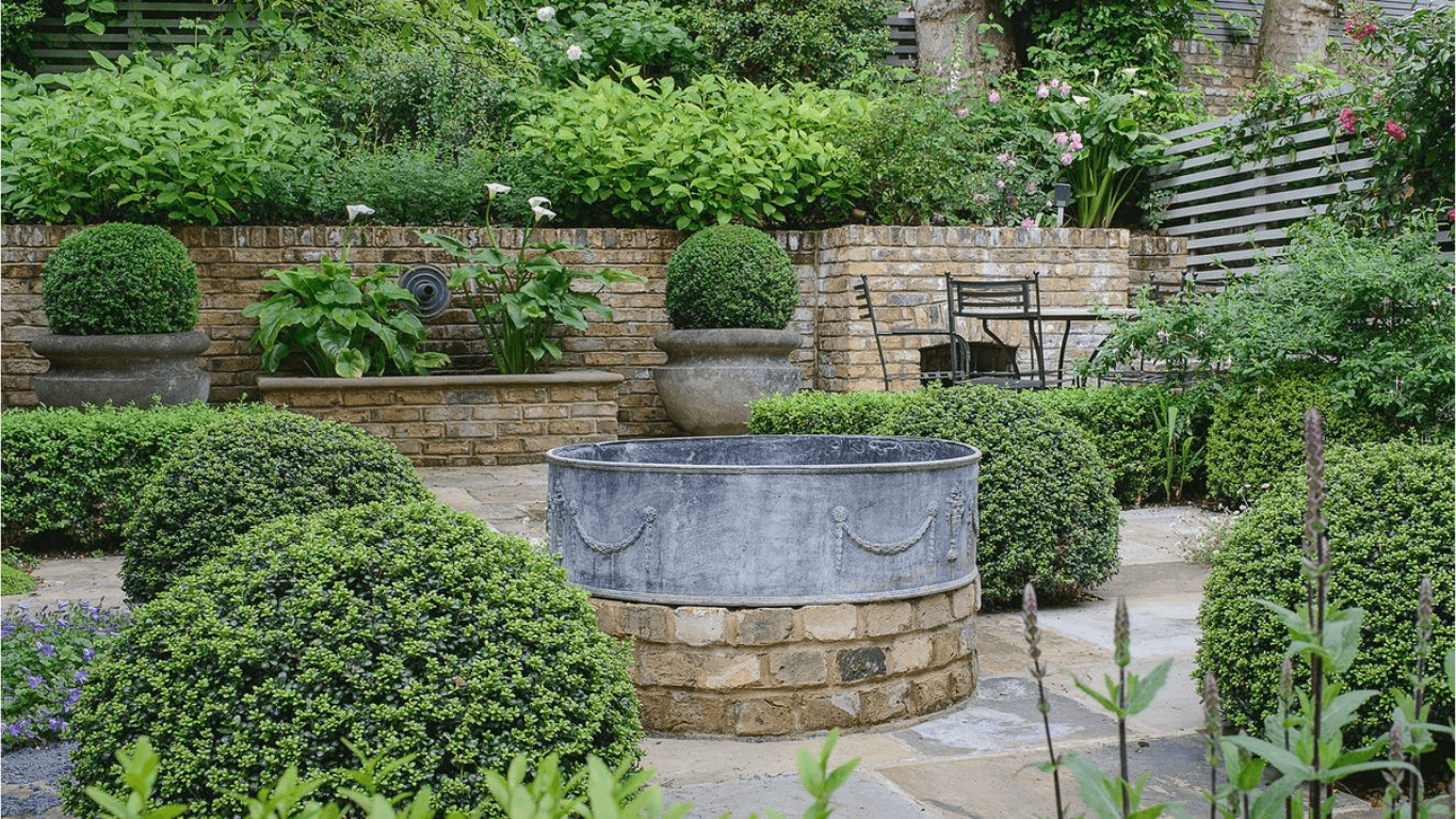 A serene garden with a large metal pot brimming with greenery, complemented by a decorative garden wall in Lakeland, FL