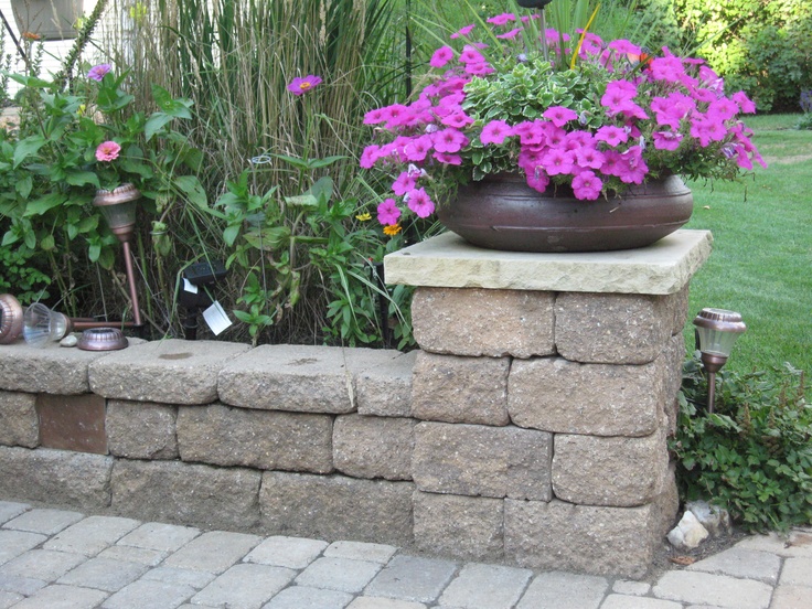 A beautiful stone wall featuring blooming flowers, adding a touch of elegance to the landscape garden setting in Lakeland, FL