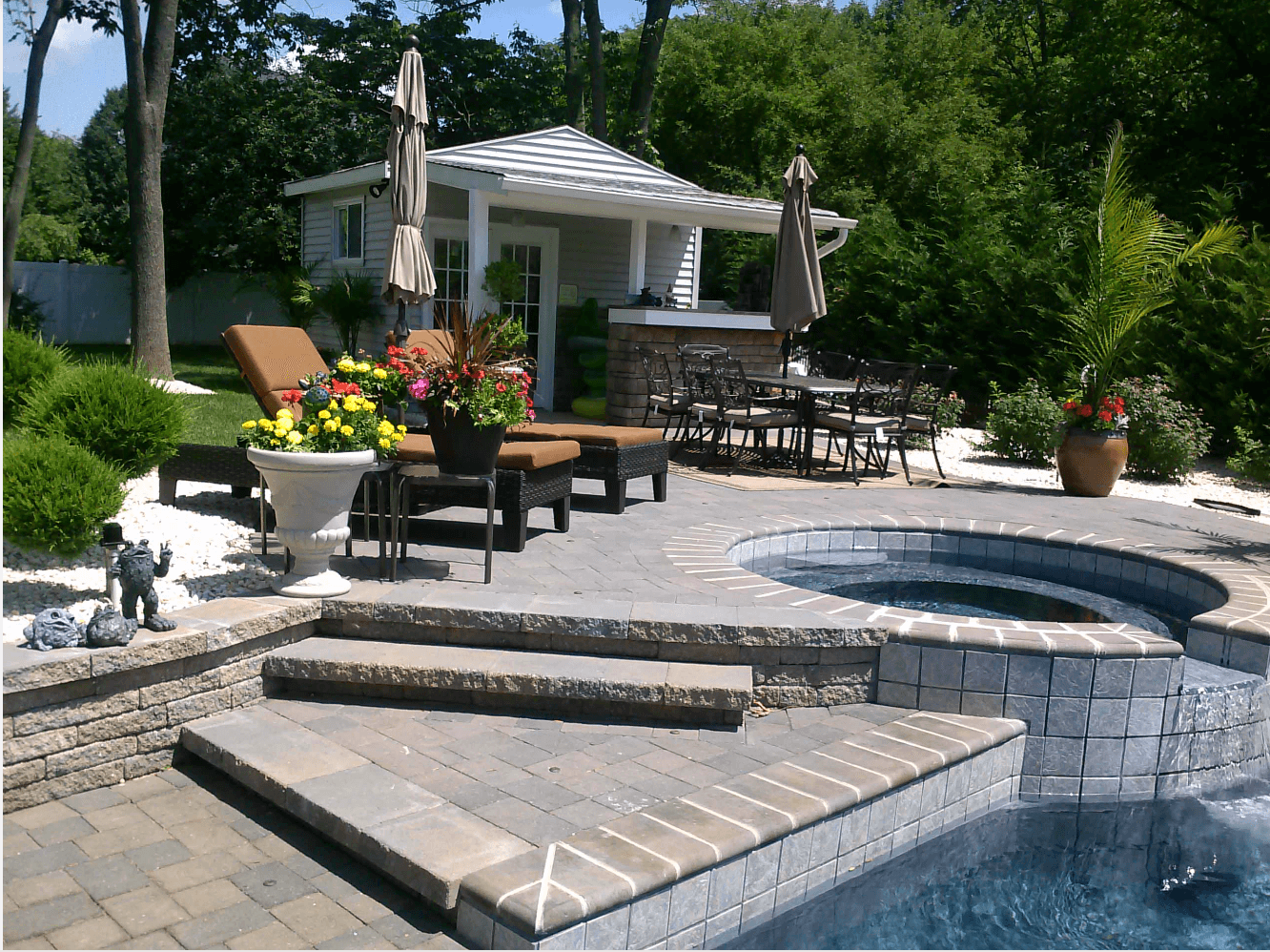 Relaxing backyard oasis showcasing a hot tub, patio furniture, and a beautiful retaining wall for a serene atmosphere in Lakeland, FL